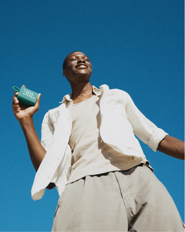 Emblem design for Madame FC depicting an M monogram in a circle with the words "Madame FC EST. 2003" inside on top of a background image of a soccer stadium.